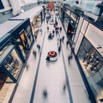 A vibrant scene capturing a busy shopping mall with modern stores and diverse shoppers on the move.